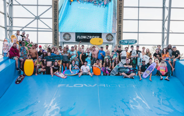 A group of people flowboarding on a flowrider surf machine at the flow tour championship at EPIC waterpark