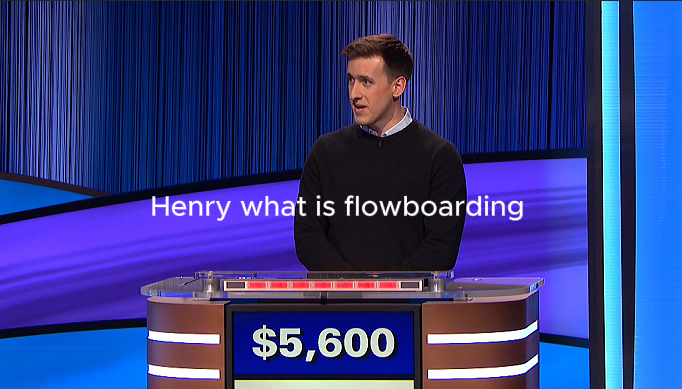 A game show contestant stands at a podium displaying $5,600. On the screen, the text reads, Henry what is FlowSurf flowboarding. Blue and purple lights are in the background.