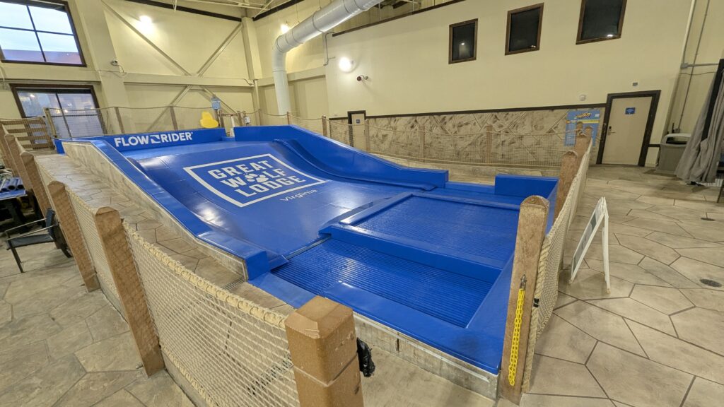 A FlowRider FlowSurf simulator at Great Wolf Lodge Virginia, featuring a blue inclined wave surface surrounded by a safety net.