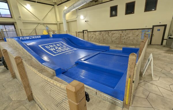A FlowRider FlowSurf simulator at Great Wolf Lodge Virginia, featuring a blue inclined wave surface surrounded by a safety net.