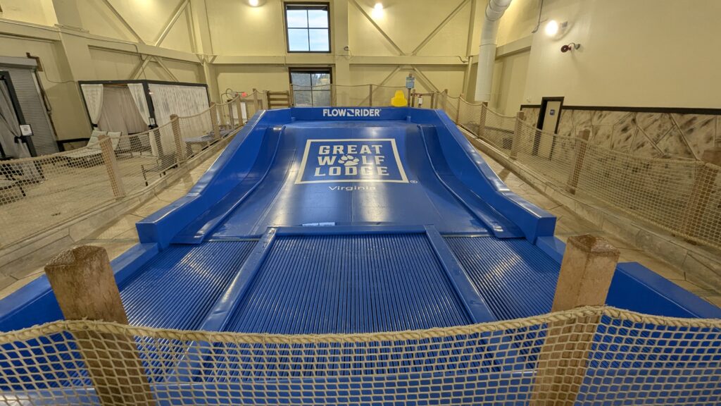 A blue FlowRider FlowSurf simulator with a Great Wolf Lodge logo in the center of the ramp.